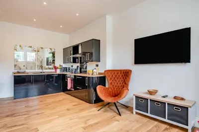 a kitchen with an orange chair and a tv on the wall at 1 Bed in West Bradford oc-g32100 in West Bradford