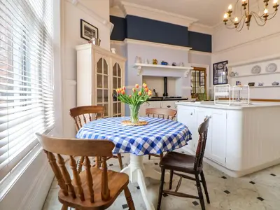a kitchen with a table with a vase of flowers on it at Ismay Lounge Apartment- Titanic Interest in Liverpool