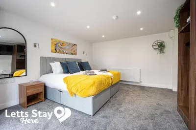 a bedroom with a large bed with a yellow blanket at Morecambe Bay Stays in Morecambe