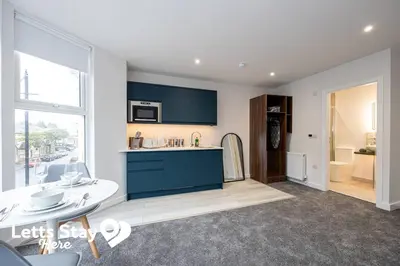 a kitchen with blue cabinets and a counter top at Morecambe Bay Stays in Morecambe