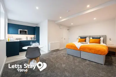 a bedroom with a king sized bed and a kitchen at Morecambe Bay Stays in Morecambe