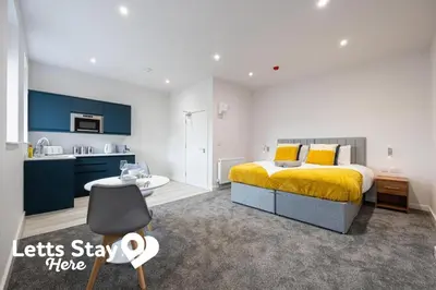 a bedroom with a king sized bed and a kitchen at Morecambe Bay Stays in Morecambe