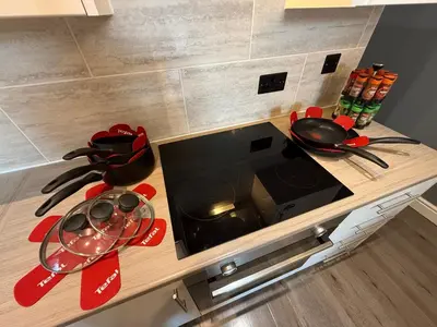 a kitchen counter with a stove top with pots and pans at Anfield Courtyard Retreat in Liverpool