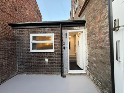 a brick building with a door and a window at Anfield Courtyard Retreat in Liverpool