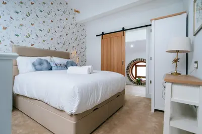 a bedroom with a large bed with white sheets at The Carriage House at the Talbot in Lytham St Annes