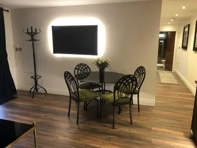 a dining room with a table and chairs and a television at Wayside Lodge in Blackpool