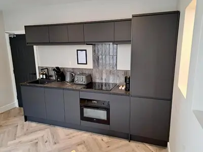 a kitchen with black cabinets and a counter top at Pleasure Beach Apartments by Central Beach Leisure in Blackpool