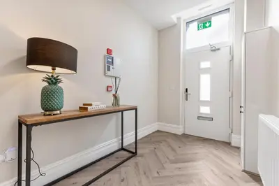 a room with a table with a lamp and a door at Pleasure Beach Apartments by Central Beach Leisure in Blackpool