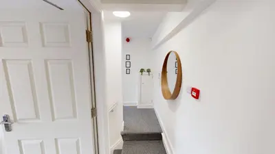 a hallway with a white door and a mirror at For Workers 10 Mins to City 5 TVs and Parking in Liverpool