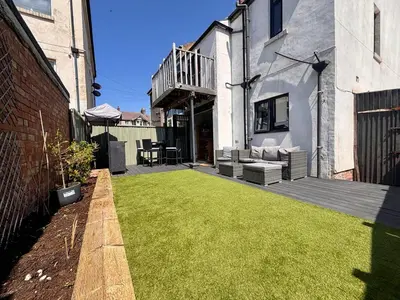 a backyard with a lawn in front of a building at Crescent House, Pleasure Beach in Blackpool