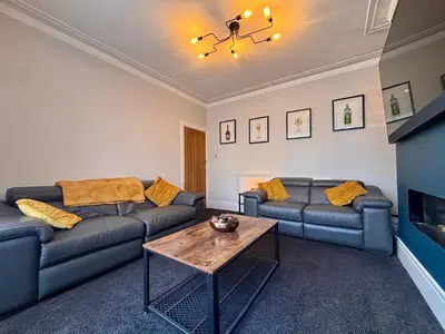 a living room with couches and a coffee table at Crescent House, Pleasure Beach in Blackpool