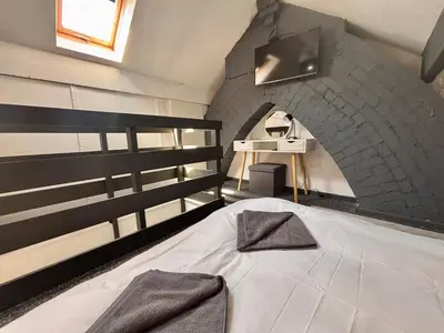 a large bed in a room with a brick wall at Crescent House, Pleasure Beach in Blackpool