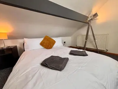 a bedroom with a white bed with two towels on it at Crescent House, Pleasure Beach in Blackpool