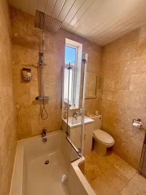a bathroom with a tub and a toilet and a sink at Crescent House, Pleasure Beach in Blackpool