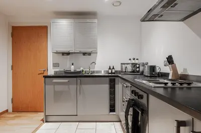 a kitchen with a sink and a stove at Modern City Apartment By Chalefor Living in Liverpool