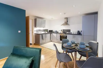 a kitchen and dining room with a table and chairs at Modern City Apartment By Chalefor Living in Liverpool