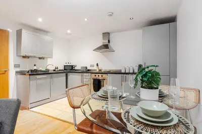 a kitchen with a table and chairs in a room at Modern City Apartment By Chalefor Living in Liverpool
