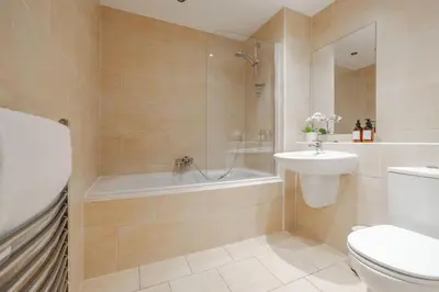 a bathroom with a tub and a toilet and a sink at Modern City Apartment By Chalefor Living in Liverpool