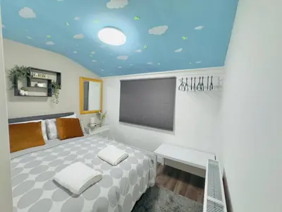 a bedroom with a bed and a blue ceiling at Room 2 Shared House in Bootle in Litherland