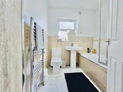 a bathroom with a toilet and a sink and a tub at Room 2 Shared House in Bootle in Litherland