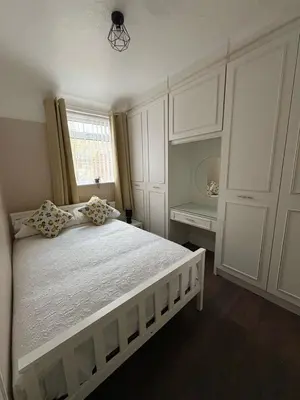 a white bedroom with a large bed and a window at Anfield Home - Sleeps 7 - 1 min walk to Stadium! in Liverpool