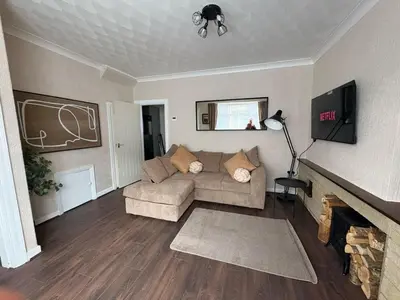 a living room with a couch and a fireplace at Anfield Home - Sleeps 7 - 1 min walk to Stadium! in Liverpool