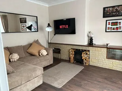 a living room with a couch and a fireplace at Anfield Home - Sleeps 7 - 1 min walk to Stadium! in Liverpool