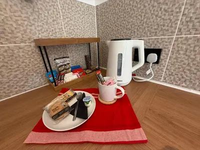 a table with a coffee maker and a plate of food at The Anfield Loft in Liverpool