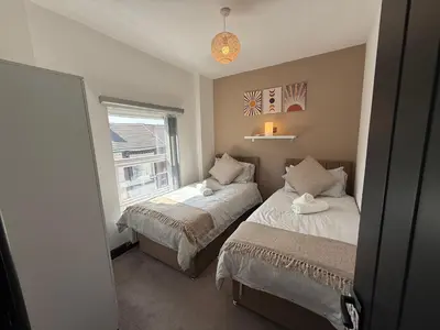 a bedroom with two beds and a window at The Anfield Loft in Liverpool
