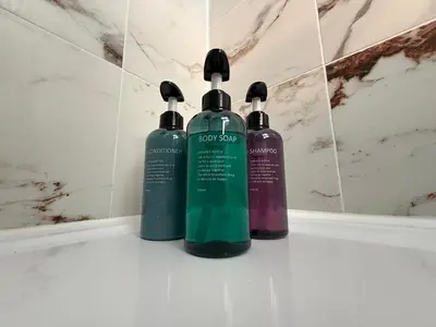 three shampoo bottles sitting on top of a bathroom sink at The Anfield Loft in Liverpool