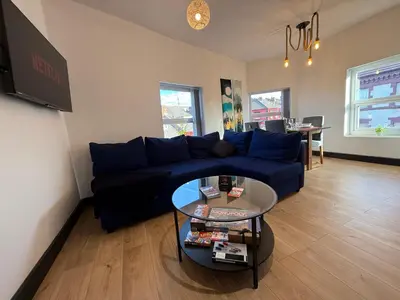 a living room with a blue couch and a table at The Anfield Loft in Liverpool