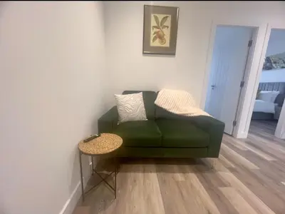 a green couch in a living room with a table at 2 Bed Preston City Centre - Sleeps 4 with 1 Free Parking Space in Preston