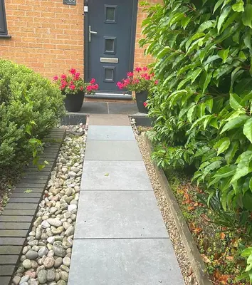 a walkway in front of a house with a blue door at Contemporary House with a Woodland Setting in Skelmersdale