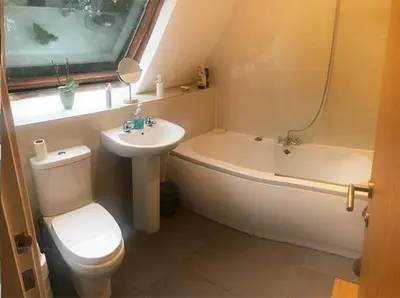 a bathroom with a toilet and a tub and a sink at Contemporary House with a Woodland Setting in Skelmersdale