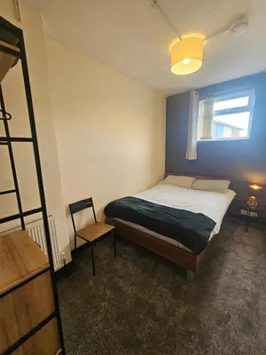 a small bedroom with a bed and a window at Birkenhead House in Bidston