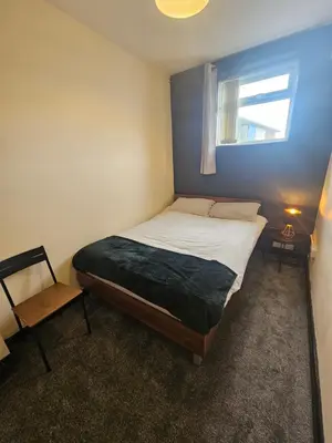 a small bedroom with a bed and a window at Birkenhead House in Bidston