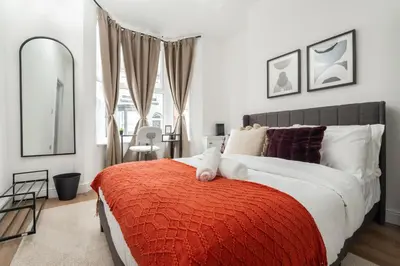 a bedroom with a large bed with a red blanket at Modern 4bedroom City Home Near LFC in Liverpool