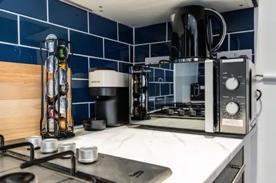a kitchen with blue tiled walls and a counter at Modern 4bedroom City Home Near LFC in Liverpool