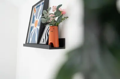 an orange vase with flowers in it on a wall at Modern 4bedroom City Home Near LFC in Liverpool