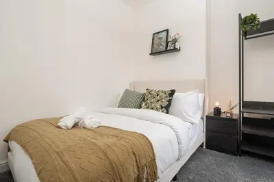 a bedroom with a white bed with a brown blanket at Modern 4bedroom City Home Near LFC in Liverpool