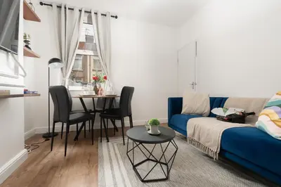 a living room with a blue couch and a table at Modern 4bedroom City Home Near LFC in Liverpool