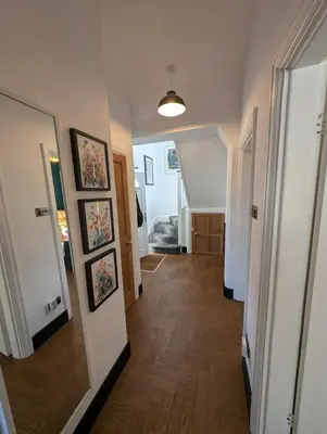 a hallway of a home with wooden floors and a hallway at Luxury 3 bed house with off road parking for 2 cars, garden, 10 minutes from city-centre in Liverpool