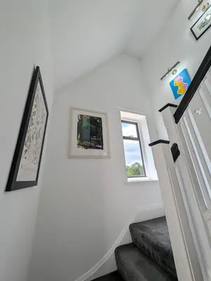 a staircase with white walls and a window at Luxury 3 bed house with off road parking for 2 cars, garden, 10 minutes from city-centre in Liverpool