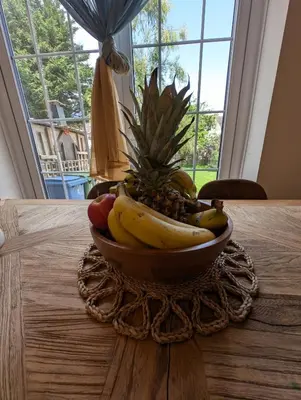 a bowl of fruit on a table with a pineapple at Luxury 3 bed house with off road parking for 2 cars, garden, 10 minutes from city-centre in Liverpool