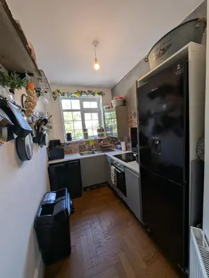 a kitchen with a black refrigerator and a sink at Luxury 3 bed house with off road parking for 2 cars, garden, 10 minutes from city-centre in Liverpool