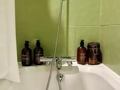 a bathroom sink with three bottles of soap at The Liverpool Loft in city centre in Liverpool
