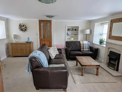a living room with a couch and a fireplace at Garth Nook Barn in Soutergate