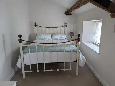 a bedroom with a metal bed in a room at Garth Nook Barn in Soutergate