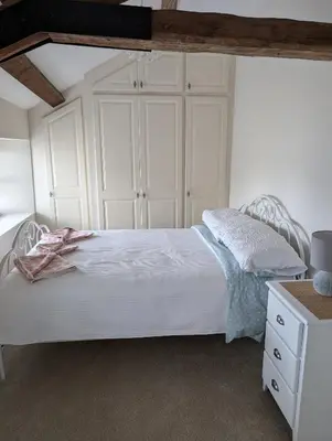 a bedroom with a white bed and a white dresser at Garth Nook Barn in Soutergate