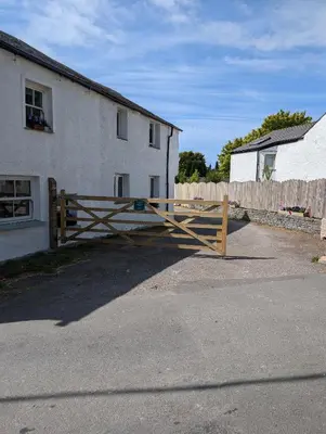 a wooden gate in front of a house at Garth Nook Barn in Soutergate